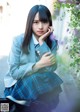 A young woman in a school uniform sitting on a bench.