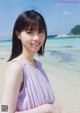 A woman standing on a beach next to the ocean.