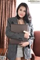 A woman in a business suit holding a laptop computer.