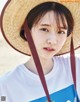 A woman wearing a straw hat on the beach.