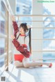 A woman in a red and white outfit is posing for a picture.