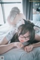 A woman laying on a bed wearing a cat ears headband.