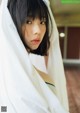 A woman with a white sheet covering her face.